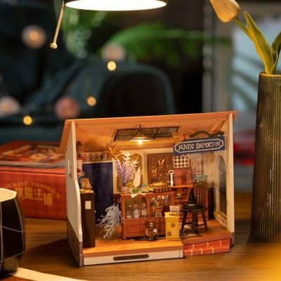 A charming miniature wizard store dollhouse with magical accessories, set on a wooden table. The tiny shop features enchanting decor, shelves filled with potion bottles, a wizard's hat, and mystical items, creating a whimsical fantasy scene. Perfect for collectors or as a decorative piece.