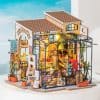 Miniature flower shop and greenhouse with vibrant floral decorations, detailed interior, and outdoor plants, perfect for collectible dolls and miniature garden enthusiasts.