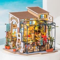 Miniature flower shop and greenhouse with vibrant floral decorations, detailed interior, and outdoor plants, perfect for collectible dolls and miniature garden enthusiasts.