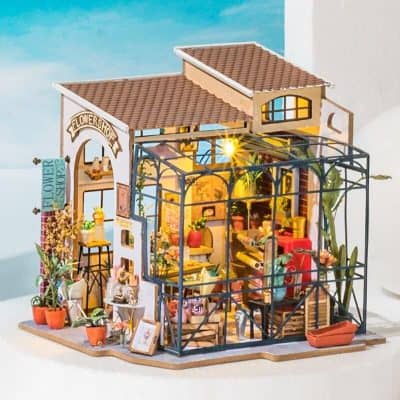 Miniature flower shop and greenhouse with vibrant floral decorations, detailed interior, and outdoor plants, perfect for collectible dolls and miniature garden enthusiasts.