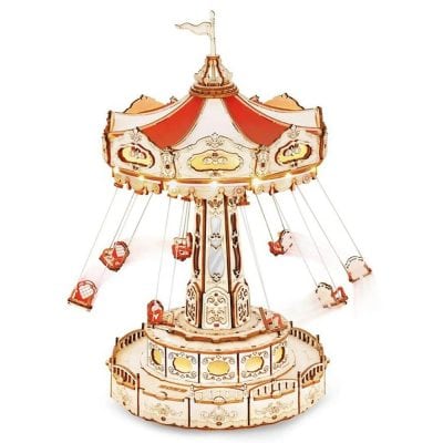 Ornamental carousel model with painted wood and metal parts, designed for children's play or vintage decor, featuring intricate craftsmanship and bright colors.