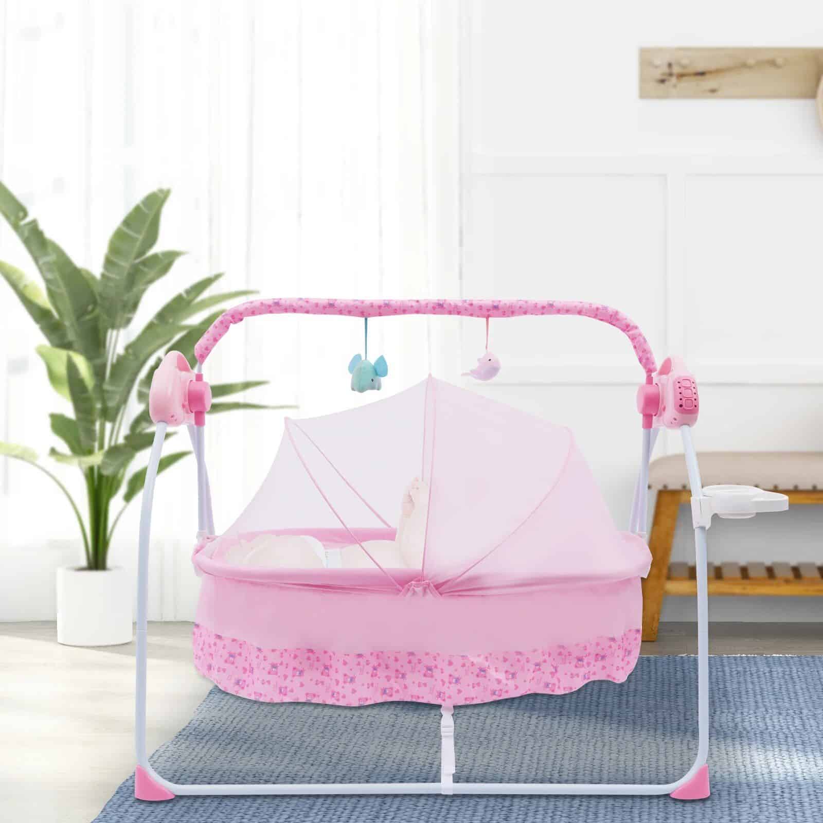 Pink baby cradle with canopy, hanging plush toys, and soft bedding, perfect for a cozy nursery environment.