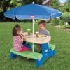 Colorful outdoor kids picnic table with an umbrella, perfect for children’s activities and meals in the yard. Durable plastic construction ensuring safety and easy cleaning for outdoor use.