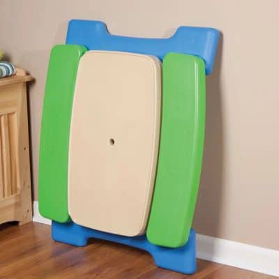 Bright baby changing station with cushioned surfaces in green, blue, and beige for safe diaper changes.