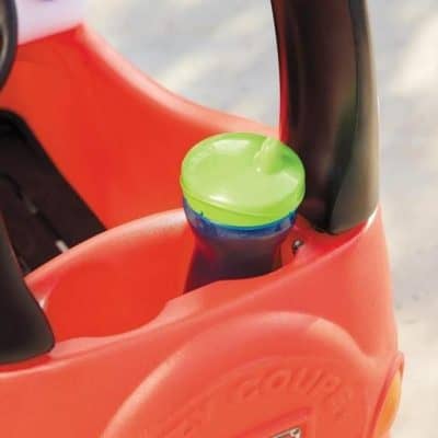 Bright green and blue kids water bottle placed in the cup holder of a toddler's red stroller, perfect for children's hydration needs.