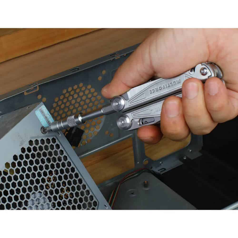 Metal torque screwdriver in hand, repairing or assembling computer hardware components.