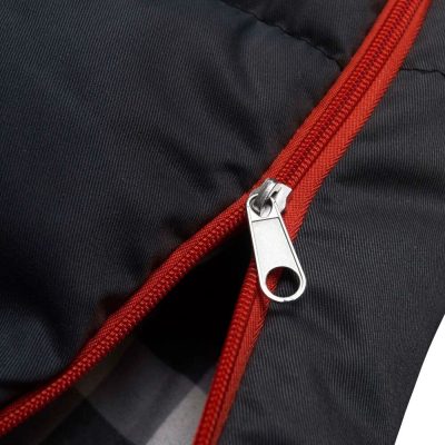 Close-up of a black jacket zipper with red trim showcasing durability and style, suitable for outdoor enthusiasts and everyday use.