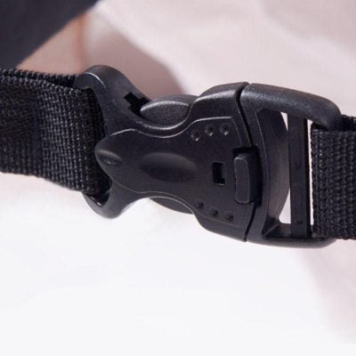 Close-up of a black adjustable strap buckle for eyeglasses with textured fabric band.