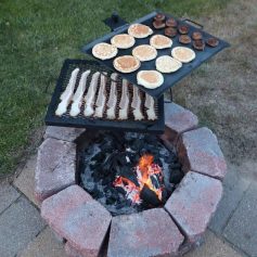 Delicious breakfast foods grilling over an open flame on a backyard fire pit, featuring pancakes, bacon, and sausage. Perfect outdoor cooking setup for a casual family meal.
