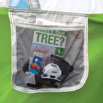 A convenient mesh travel organizer containing sunglasses, reading glasses, and a colorful card, perfect for storing and protecting eyewear and accessories on the go.