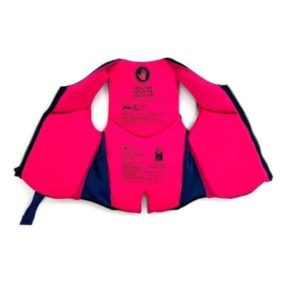 Bright pink adult life vest with safety labels and adjustable straps, perfect for water activities and ensuring safety during swimming or boating.