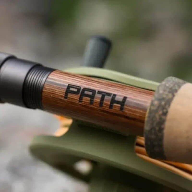 A close-up of a walking stick with the word "PATH" inscribed on it, symbolizing guidance and journey, representing the store's focus on vision and eyewear solutions for all ages.