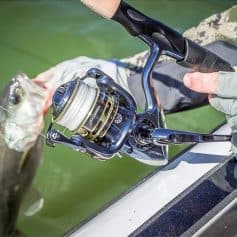 High-quality fishing reel used for sport fishing, mounted on boat with a fish caught on the hook, showcasing fishing tackle expertise and equipment at Monalisa Store.