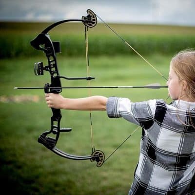 Child shooting with a compound bow outdoors, emphasizing children's archery gear, safety, and beginner-friendly options from Monalisa Store.