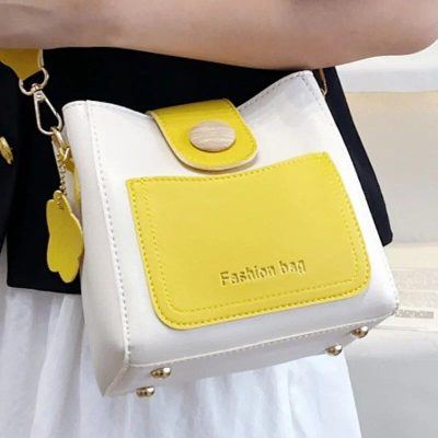 Fashion handbag with yellow and white design, featuring a front pocket labeled