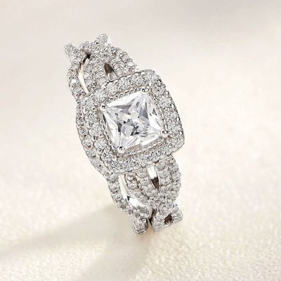 Luxurious diamond engagement ring with a large square-cut center stone surrounded by smaller pave set diamonds, crafted in high-quality white gold or platinum. Perfect for special occasions and milestones.