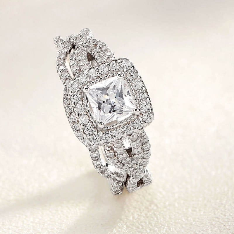 Luxurious diamond engagement ring with a large square-cut center stone surrounded by smaller pave set diamonds, crafted in high-quality white gold or platinum. Perfect for special occasions and milestones.