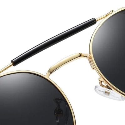 Fashionable sunglasses with gold frames, dark lenses, and adjustable nose pads for stylish eye protection and daily wear.
