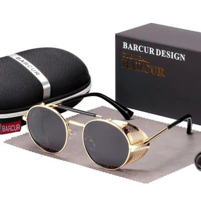 Stylish gold-framed round sunglasses with dark lenses, perfect for fashion-conscious individuals. Comes with a protective case and packaging for a complete accessory set.
