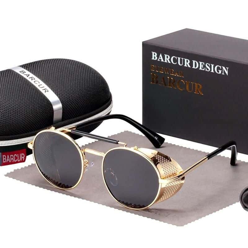 Stylish gold-framed round sunglasses with dark lenses, perfect for fashion-conscious individuals. Comes with a protective case and packaging for a complete accessory set.