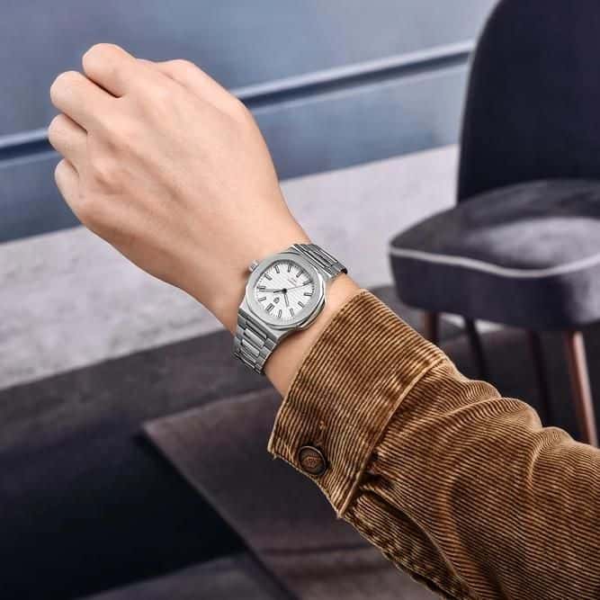 Stainless steel luxury watch on a person's wrist, showcasing elegant design and craftsmanship, perfect for upscale fashion and medical professionals.