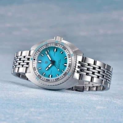 Luxury men's wristwatch with stainless steel band, turquoise dial, water resistant, ideal for fashionable accessories and timepiece enthusiasts.