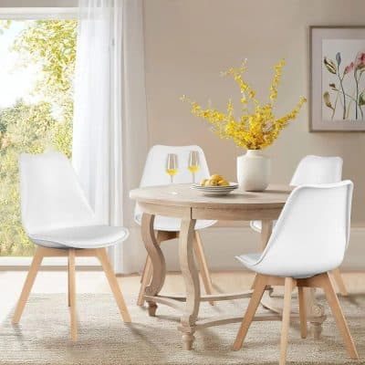 Stylish white dining chairs with light wooden legs surround a rustic table with yellow accents, ideal for modern home interiors and comfortable family meals.