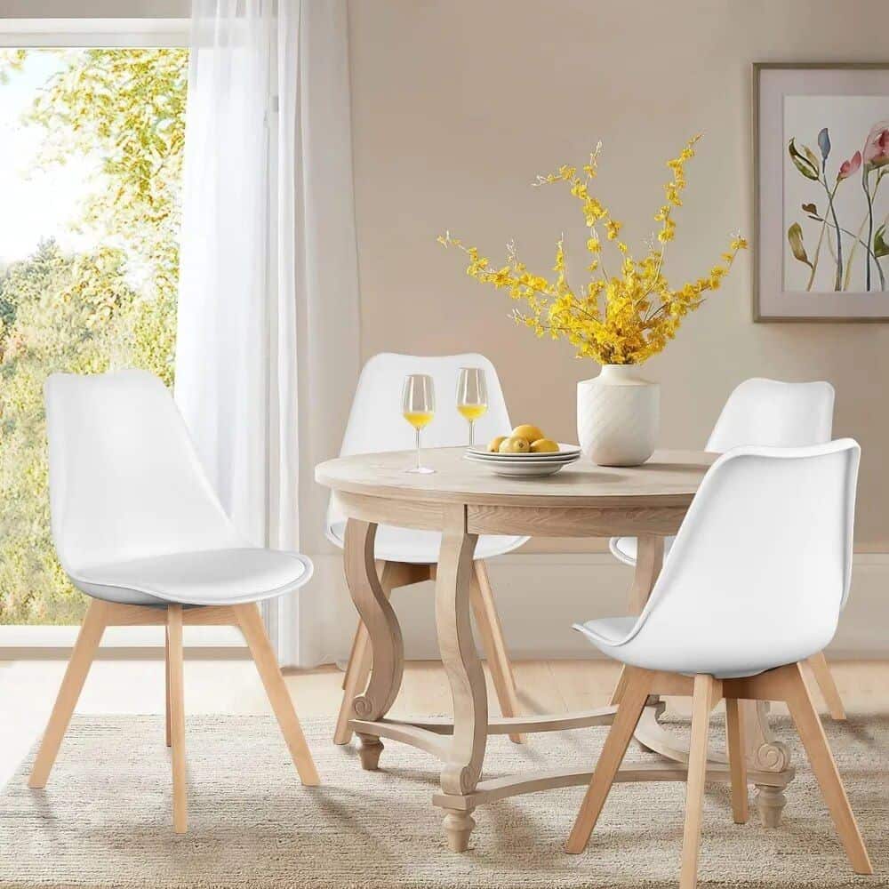 Stylish white dining chairs with light wooden legs surround a rustic table with yellow accents, ideal for modern home interiors and comfortable family meals.