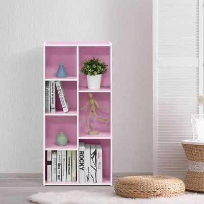 A stylish pink bookshelf displaying books, decorative vases, a potted plant, and a wooden mannequin, perfect for modern interior decor and home organization.