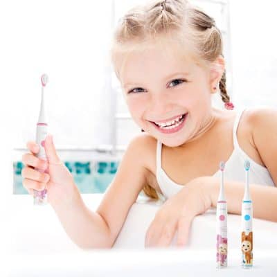 Bright young girl smiling with a colorful cartoon toothbrush in bathroom setting for kids dental hygiene.