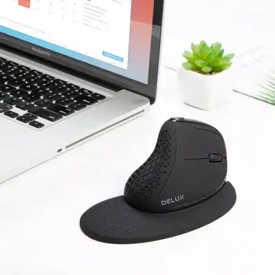 Ergonomic black computer mouse with textured grip, designed for smooth handling, placed next to a laptop and a small potted succulent on a clean workspace.