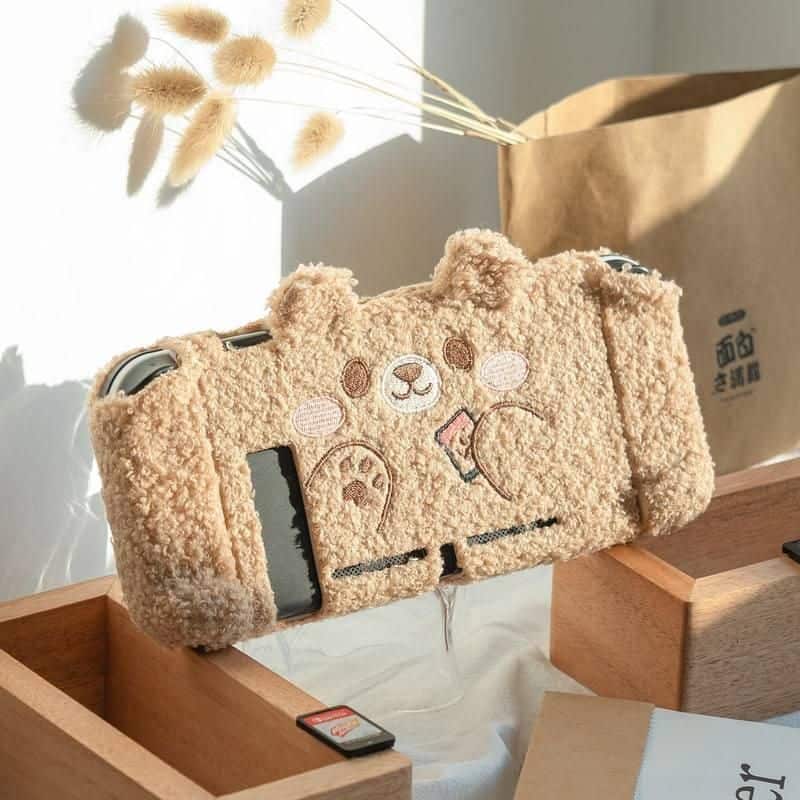 Adorable beige bear-shaped plush camera bag with embroidered facial features, perfect for carrying your essentials in style. Soft, cozy, and trendy, ideal for fashion-forward and animal lover audiences.