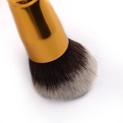 Close-up of a high-quality makeup brush with soft bristles and a sleek gold handle, ideal for flawless makeup application, perfect for beauty salons, makeup artists, and cosmetic enthusiasts.