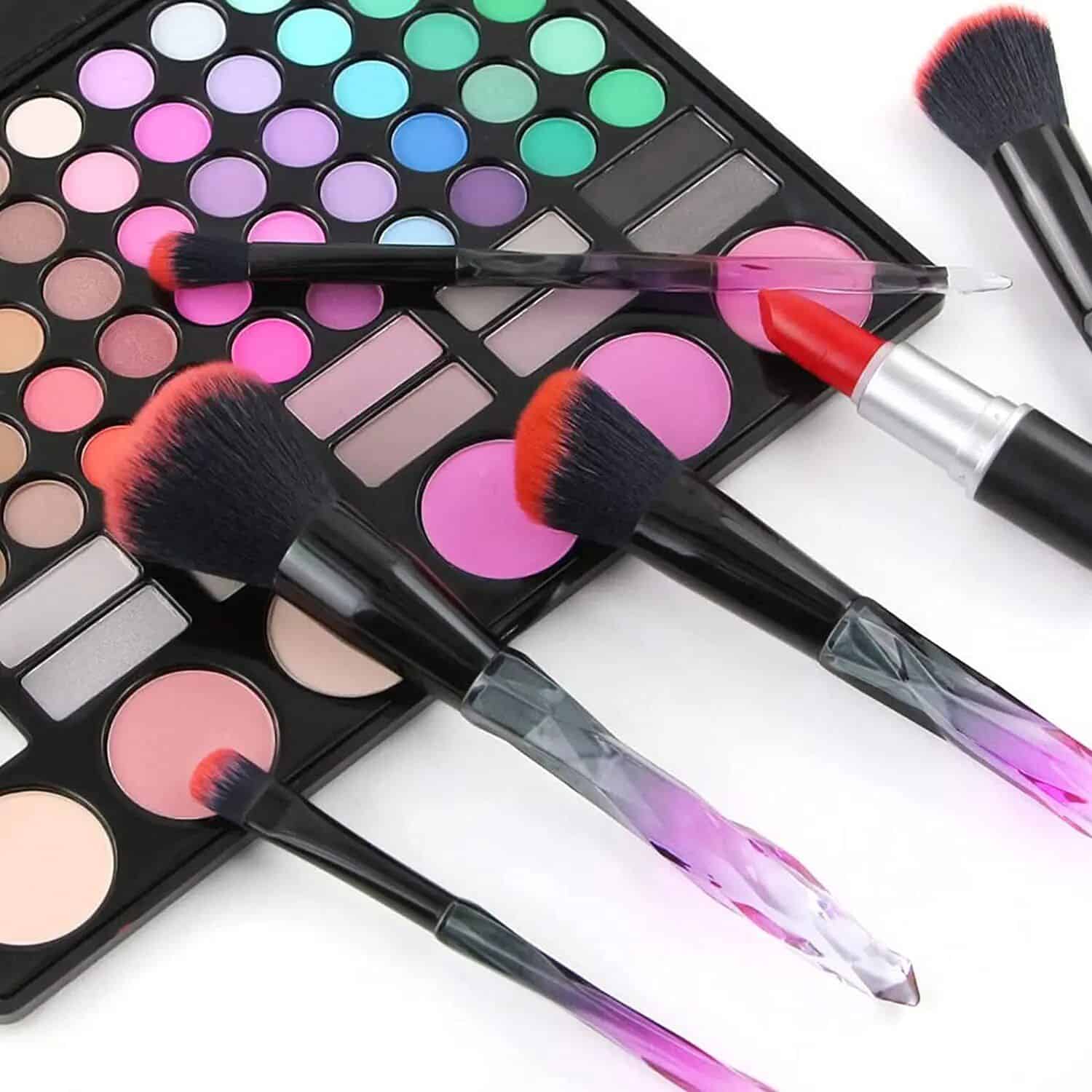 High-quality makeup brushes with black handles and pink-tipped bristles, perfect for blending eyeshadow, blush, and foundation. Includes an extensive eyeshadow palette with colorful shades.