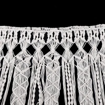 Decorative white macrame curtain for home or event decoration, handcrafted knotted textile art, stylish window or wall hanging.
