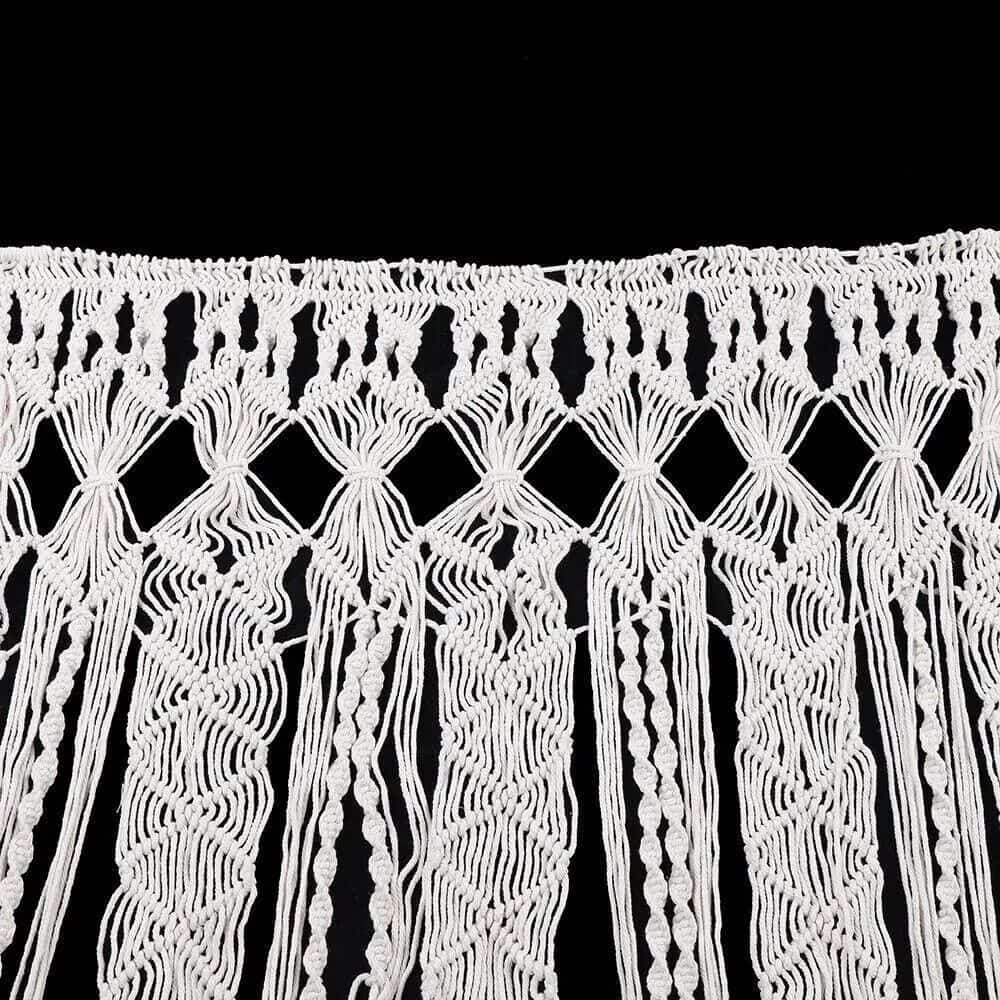Decorative white macrame curtain for home or event decoration, handcrafted knotted textile art, stylish window or wall hanging.