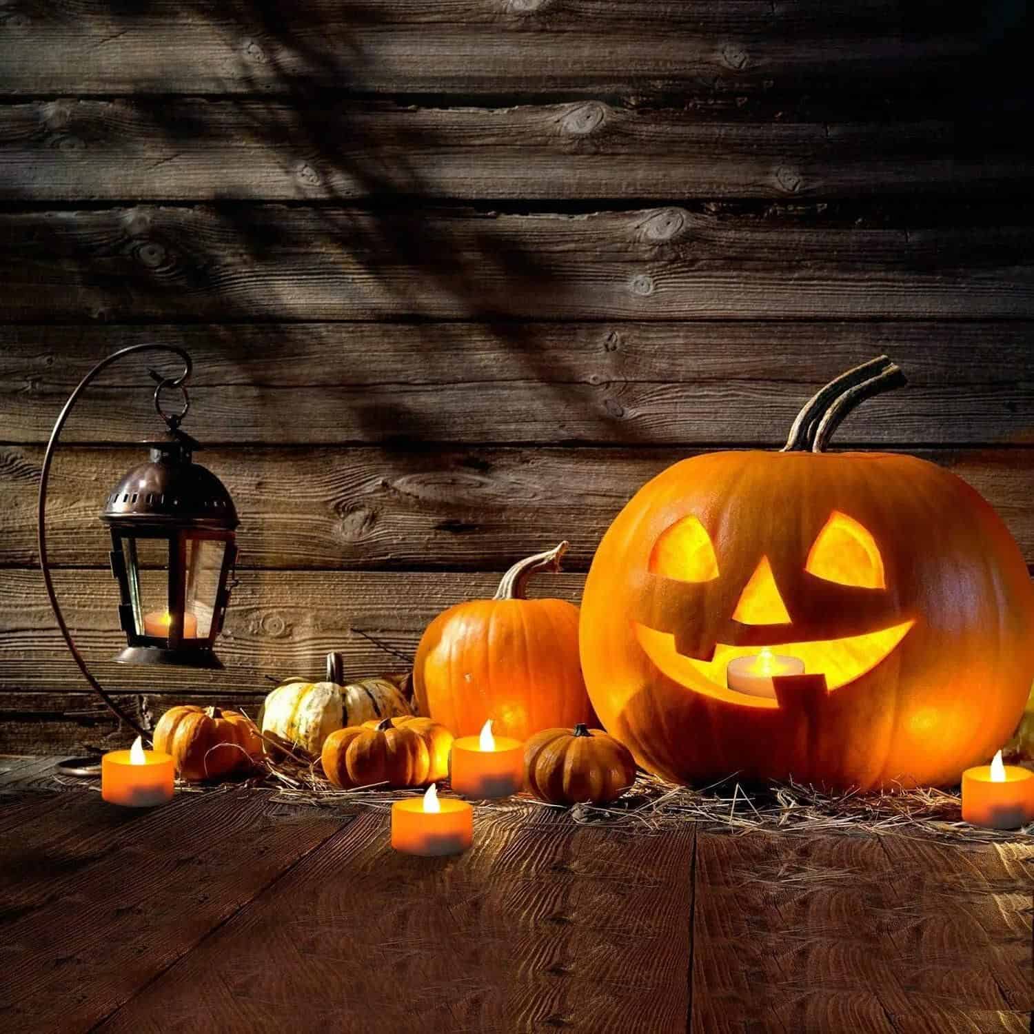 Illuminated carved pumpkin with a classic smile, surrounded by smaller pumpkins and candles, creating a cozy autumn or Halloween ambiance at Monalisa Store.