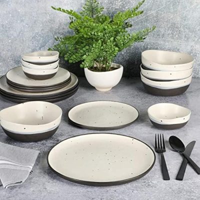 Elegant ceramic dinnerware with black accents, perfect for modern dining. Includes bowls, plates, and utensils, ideal for everyday meals or special occasions.