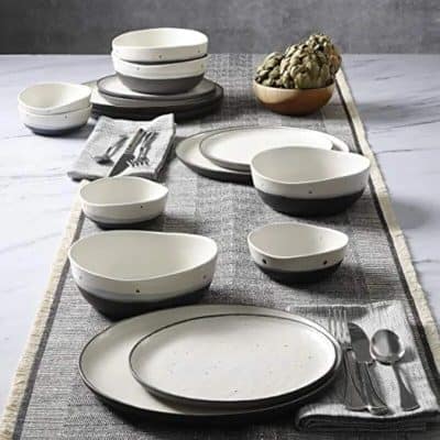 Elegant black and white ceramic dinnerware with simple polka dot accents for modern dining. Perfect for serving meals in style.