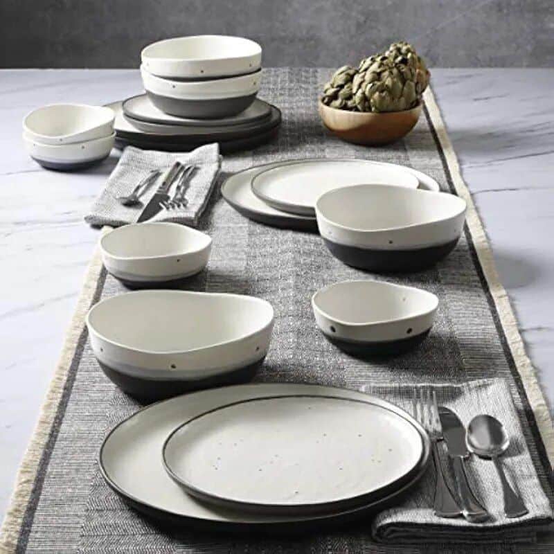 Elegant black and white ceramic dinnerware with simple polka dot accents for modern dining. Perfect for serving meals in style.