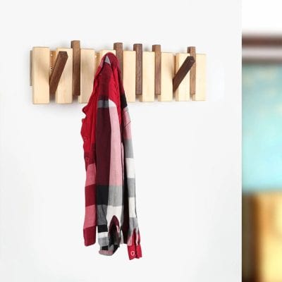 Light-colored wood wall hook rack with red, pink, black, and white striped scarf hanging for modern home decor.