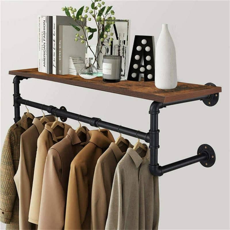 Elegant clothing storage with industrial pipe design and wooden shelf for retail or home.
