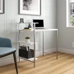 Comfortable workspace with sleek white desk and multi-tier shelf for keeping office essentials organized. Bright lighting from window, ideal for a home office, studying, or telecommuting environment.