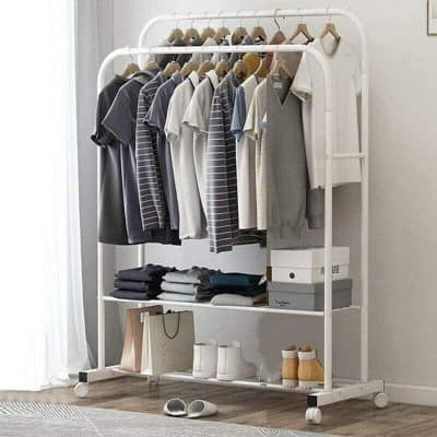 A modern white clothing rack showcasing neatly hung casual shirts, pants, and shoes, perfect for wardrobes or retail stores.