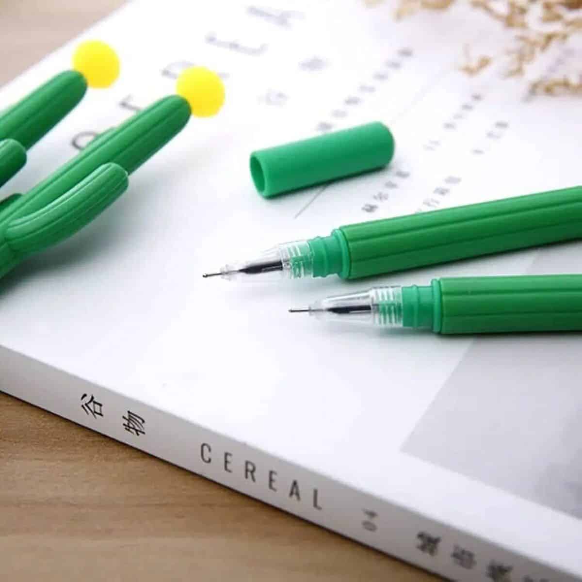 Images of green pen set with removable caps, perfect for office or art projects, displayed on paper. Great for professional, academic, or creative use, emphasizing quality and comfort.