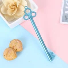 Cute blue eye-shaped eyelash curler, perfect for enhancing eye beauty and makeup routines, featured alongside cookies and decorative flowers for a stylish beauty accessory display.