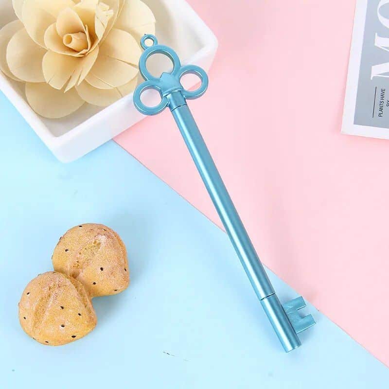 Cute blue eye-shaped eyelash curler, perfect for enhancing eye beauty and makeup routines, featured alongside cookies and decorative flowers for a stylish beauty accessory display.