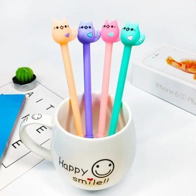 Adorable cat-themed pens with smiling faces in pink, blue, purple, and green, perfect for writing, office decor, or gift ideas for kids and students.