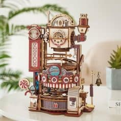A detailed wooden candy factory toy model featuring colorful machinery, conveyor belts, and whimsical sweet treats, perfect as a decorative piece or educational toy for children.