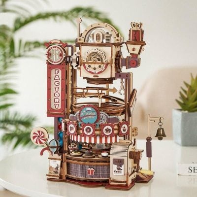 A detailed wooden candy factory toy model featuring colorful machinery, conveyor belts, and whimsical sweet treats, perfect as a decorative piece or educational toy for children.